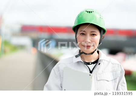 橋の建設現場とヘルメットを被った作業服姿の女性 橋の建設現場とヘルメットを被った作業服姿の女性 119331595