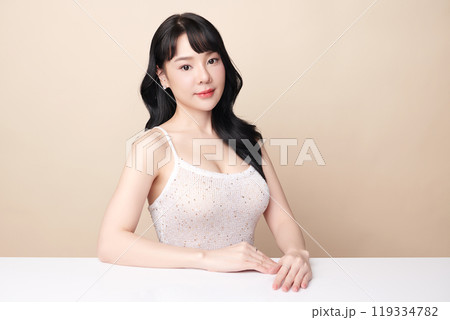 Beautiful young asian woman with clean fresh skin on beige background, Face care, Facial treatment, Cosmetology, beauty and spa, Asian women portrait. Beautiful young asian woman with clean fresh skin on beige background, Face care, Facial treatment, Cosmetology, beauty and spa, Asian women portrait. 119334782