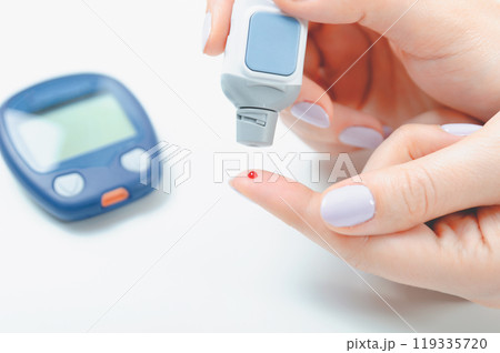 Woman is holding a glucometer 119335720