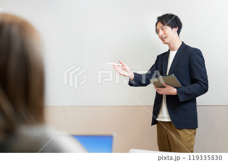 ホワイトボードの前に立って講義をする男性 119335830