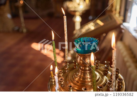 An Ornate Gold Cross Encircled by Colorful Candles Within a Beautiful Church Interior An Ornate Gold Cross Encircled by Colorful Candles Within a Beautiful Church Interior 119336582