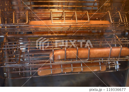 Hot Dogs Cooking in a Commercial Rotisserie, an easy and popular snack at any gathering or event 119336677