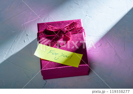 Gift box with a note on a textured background. 119338277