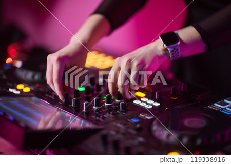 control DJ for mixing music with blurred people dancing at party in nightclub. control DJ for mixing music with blurred people dancing at party in nightclub. 119338916