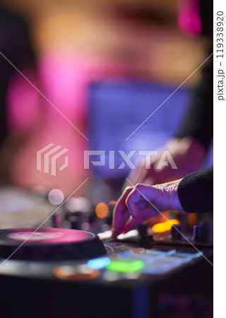 control DJ for mixing music with blurred people dancing at party in nightclub. control DJ for mixing music with blurred people dancing at party in nightclub. 119338920