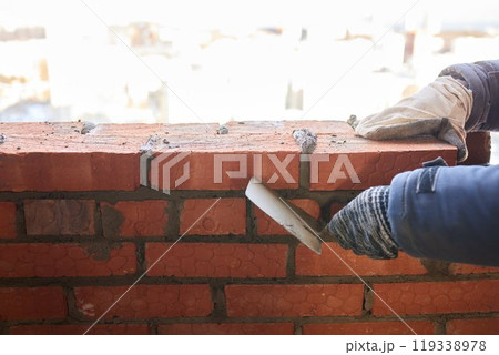 professional construction worker laying bricks and building barbecue in industrial site. Detail of hand adjusting bricks professional construction worker laying bricks and building barbecue in industrial site. Detail of hand adjusting bricks 119338978