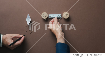 Top view of male and female hands assembling a Do it or Dont quit sign Top view of male and female hands assembling a Do it or Dont quit sign 119340793