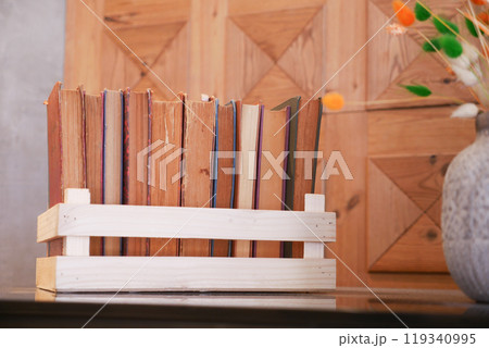 Cozy reading nook with a wooden bookshelf, books, and orange flowers, perfect for literature lovers Cozy reading nook with a wooden bookshelf, books, and orange flowers, perfect for literature lovers 119340995