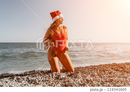 Woman in a Red Swimsuit and Santa Hat on the Beach 119341605