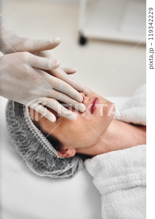 A woman receives a facial treatment in a serene spa environment A woman receives a facial treatment in a serene spa environment 119342229