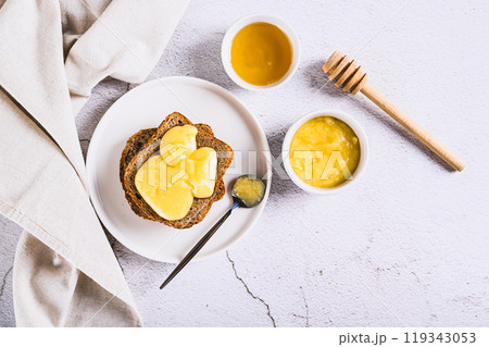 Morning sandwiches on grain bread with honey butter on a plate on the table top view Morning sandwiches on grain bread with honey butter on a plate on the table top view 119343053