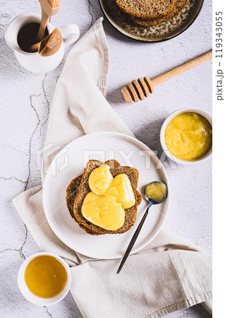 Delicious toasts with honey butter on a plate on the table top and vertical view 119343055