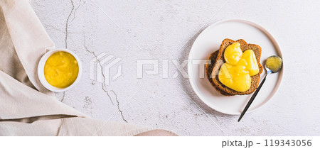 Delicious toasts with honey butter on a plate on the table top view web banner 119343056