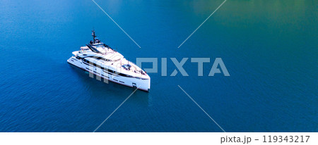 A snow-white modern yacht stands at anchor in an azure bay 119343217