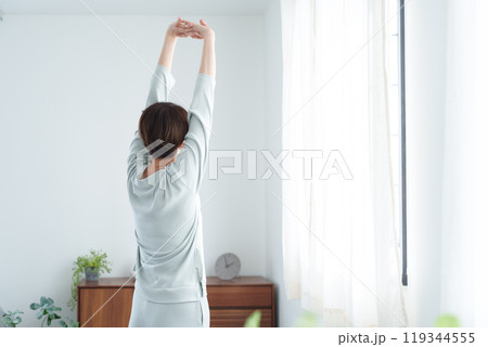 朝パジャマでストレッチする女性 119344555
