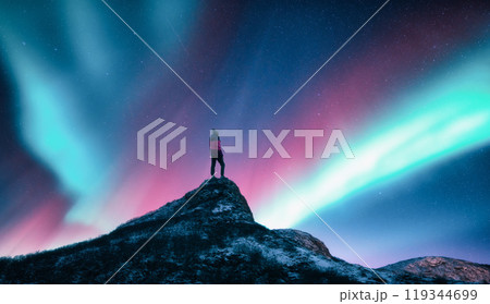 Northern lights and woman on mountain peak at night. Aurora 119344699