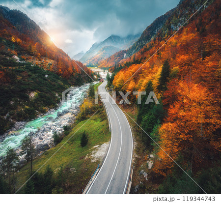 Aerial view of curvy road and orange forest in mountains in fall Aerial view of curvy road and orange forest in mountains in fall 119344743