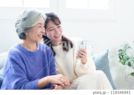 おばあちゃんにスマートフォンを教える孫 おばあちゃんにスマートフォンを教える孫 119346941