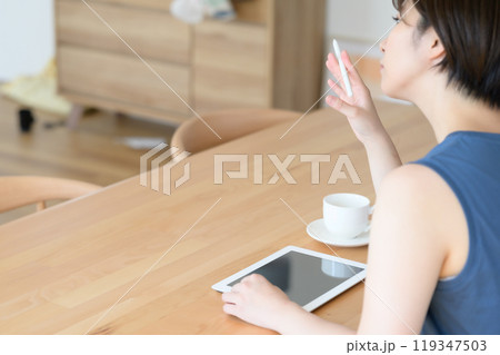 タッチペンを指で回す女性　　 119347503