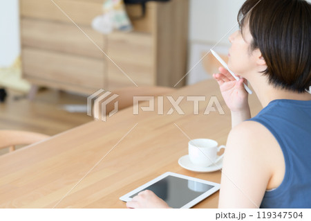 タッチペンを指で回す女性　　 119347504