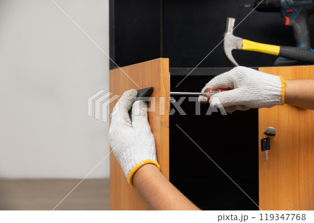 Handyman fixing cabinet door handle. Handyman fixing cabinet door handle. 119347768