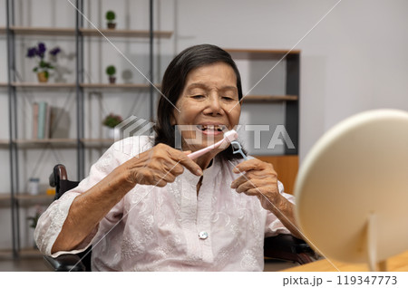 Elderly asian woman brushing teeth with brush with dental floss. 119347773