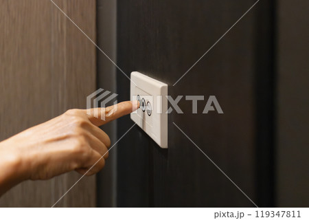 Neighbour pressing the door bell button at the front of room 119347811