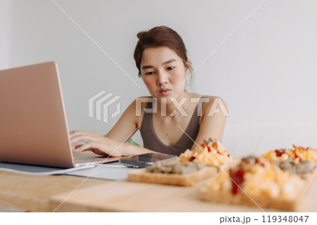 Woman is working at home with cozy clothes and breakfast meal. 119348047