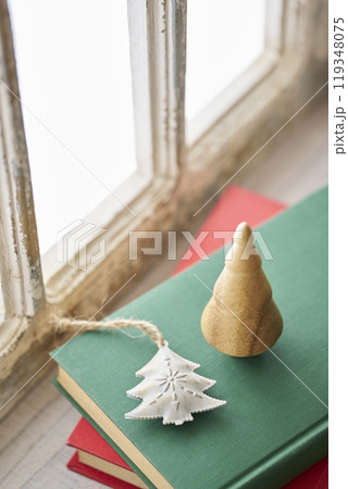 アンティークな窓辺に置かれた古い洋書とクリスマス小物 119348075