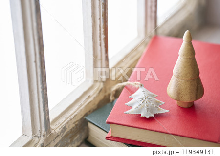 アンティークな窓辺に置かれた古い洋書とクリスマス小物 119349131
