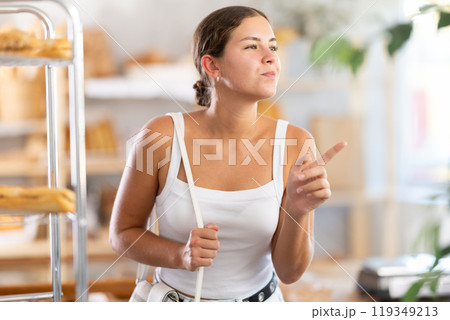 Young woman looking around in bakery Young woman looking around in bakery 119349213