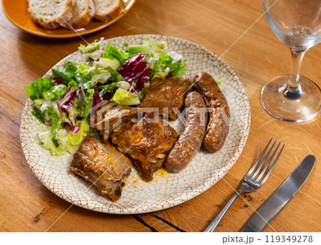 Fried butifarra sausages with fried ribs and fresh vegetables. 119349278