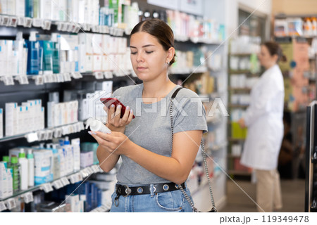 Young woman looking for cosmetic product from photo on internet Young woman looking for cosmetic product from photo on internet 119349478