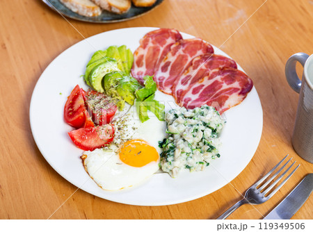 Breakfast plate containing fried egg, ham, tomato, avocado and porridge Breakfast plate containing fried egg, ham, tomato, avocado and porridge 119349506