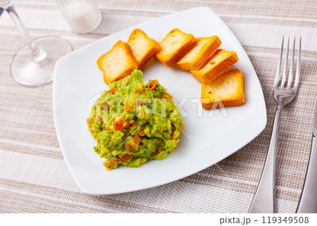 Guacamole dip served with toasted bread 119349508
