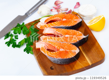 Raw salmon steaks with lemon, parsley, garlic Raw salmon steaks with lemon, parsley, garlic 119349526
