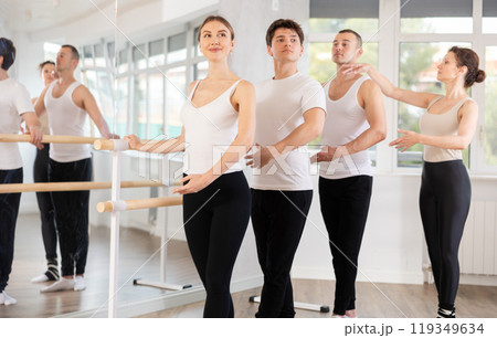 Group practicing ballet positions at barre with female instructor Group practicing ballet positions at barre with female instructor 119349634