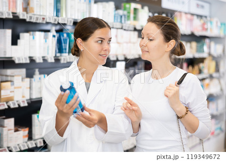 Woman pharmacist helping woman customer to choose cosmetic product Woman pharmacist helping woman customer to choose cosmetic product 119349672