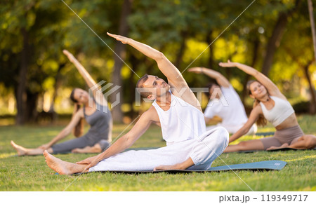 Man performing stretching exercises at outdoor yoga session Man performing stretching exercises at outdoor yoga session 119349717