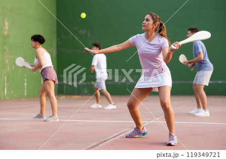 Portrait of sporty girl playing paleta fronton on outdoor court, ready to hit ball. Healthy and active lifestyle concept 119349721
