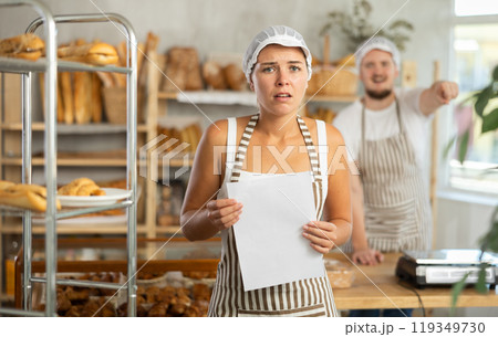 Young girl stands with her back to angry man pointing at the door 119349730