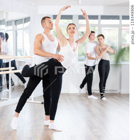 Ballet partners mastering paired technique at group class in studio Ballet partners mastering paired technique at group class in studio 119349906