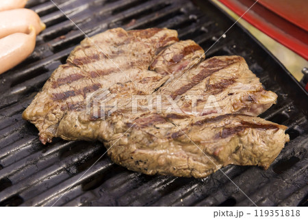 ガスグリルで焼いたステーキ肉とソーセージ　バーベキューイメージ 119351818
