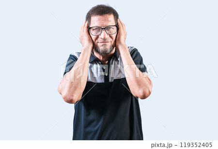 Elderly person ignoring the noise, covering ears. Displeased senior man covering his ears isolated 119352405