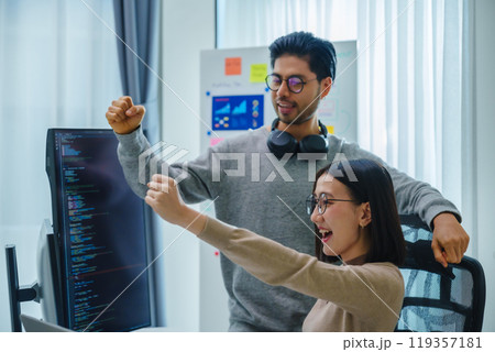 asian and Indian Developer team clapping hand for project success  with software computer at office 119357181
