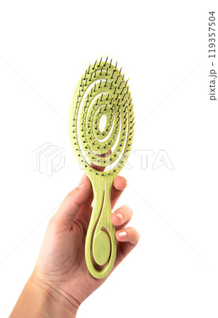 Female hand holding aroma hair comb for massage of head isolated on white background. Female hand holding aroma hair comb for massage of head isolated on white background. 119357504