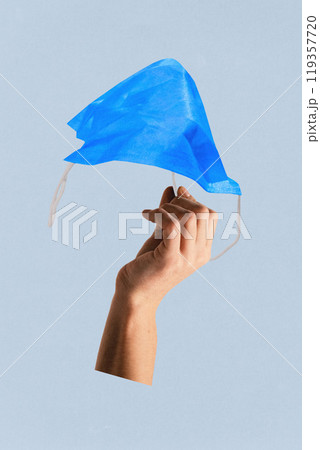 Contemporary art collage. Blue face mask held by hand, illustrating protection and hygiene. Modern and minimalist depiction of health precautions. Ad 119357720
