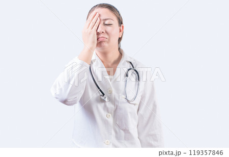 Stressed female doctor with hand on forehead isolated. Exhausted young female doctor with hand on forehead Stressed female doctor with hand on forehead isolated. Exhausted young female doctor with hand on forehead 119357846
