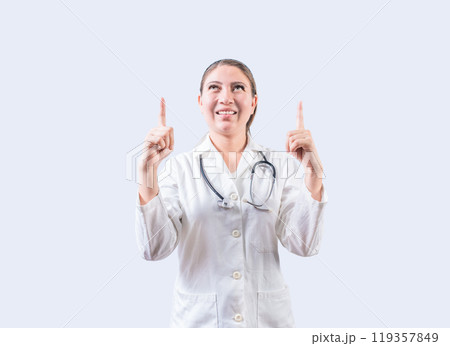 Happy female doctor pointing a promotion up. Smiling female doctor looking and pointing up isolated Happy female doctor pointing a promotion up. Smiling female doctor looking and pointing up isolated 119357849