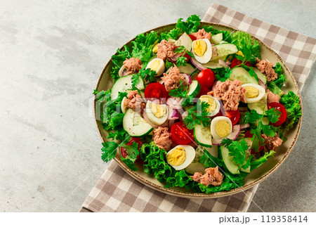 Tuna salad, vegetable salad with quail eggs, lettuce, red onion and cucumbers, on a light gray table, keto food, lifestyle, healthy eating, selective focus, top view, no people, 119358414